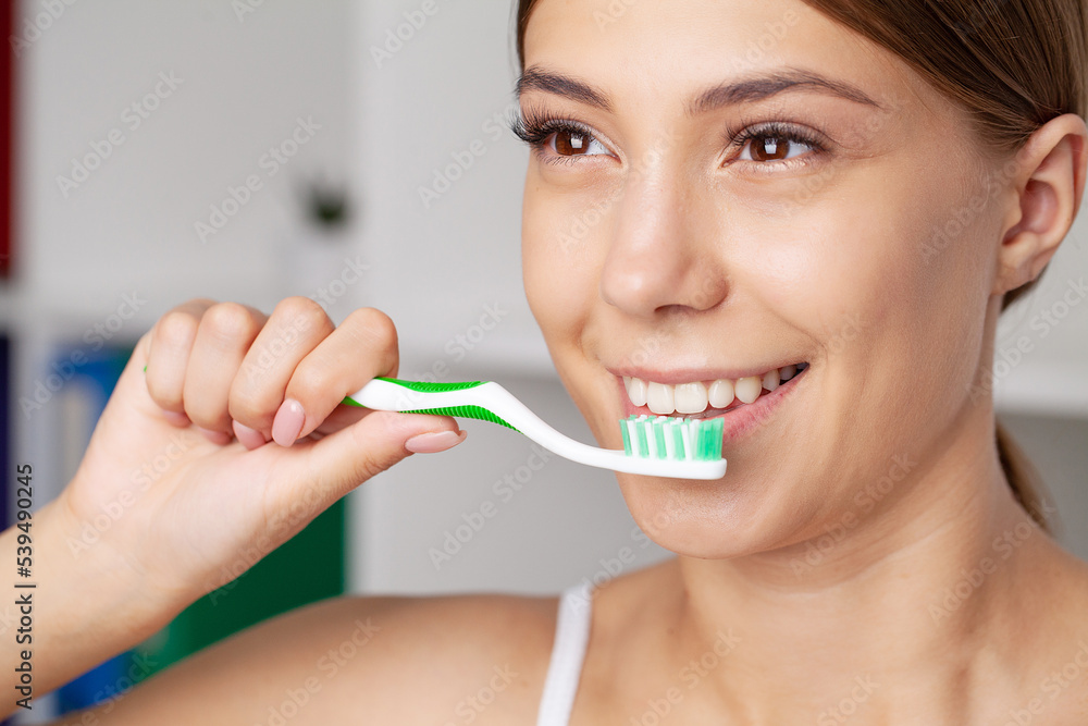 Beautiful young woman brush her teeth in the bathroom Beautiful young woman brush her teeth in the bathroom