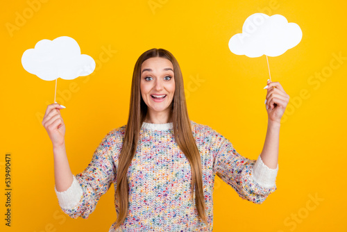 Photo of adorable young woman wear sweater holding two paper clouds smiling isolated bright color background