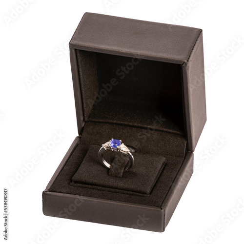 Bague avec pierre précieuse bleu et diamants dans on écrin noir sur fond blanc packshot