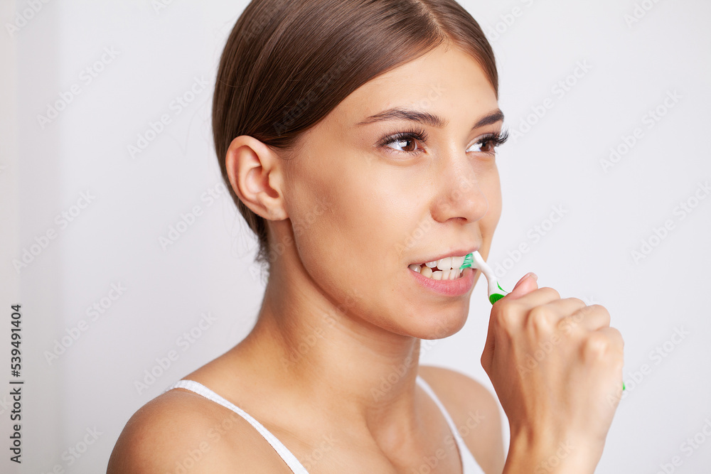 Beautiful young woman brush her teeth in the bathroom Beautiful young woman brush her teeth in the bathroom