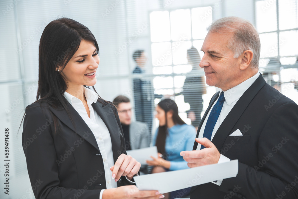 businessman and businesswoman discussing a business document businessman and businesswoman discussing a business document