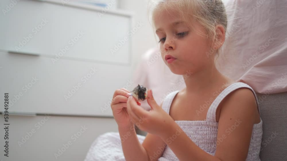 Caucasian child girl is painting watercolor paint on small ceramic figure with fun. Kids arts and crafts creative activity class at home. Little girl make ceramic decor sitting floor Caucasian child girl is painting watercolor paint on small ceramic figure with fun. Kids arts and crafts creative activity class at home. Little girl make ceramic decor sitting floor