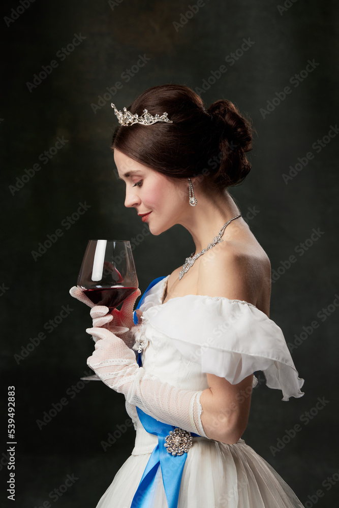 Aroma and flavor. Young elegant woman in image of princess or viscountess tasting red wine isolated on dark vintage background. Art, beauty, history, eras comparison Aroma and flavor. Young elegant woman in image of princess or viscountess tasting red wine isolated on dark vintage background. Art, beauty, history, eras comparison