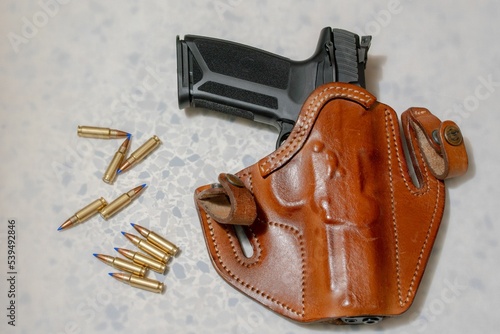 Gun in brown holster on white background photo