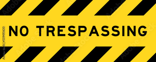Yellow and black color with line striped label banner with word no trespassing photo