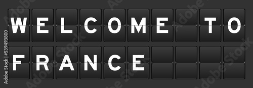 Black color analog flip board with word welcome to france on gray background