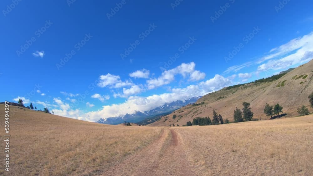 Video of a car driving on a hill on a country road under blue sky. Video of a car driving on a hill on a country road under blue sky.