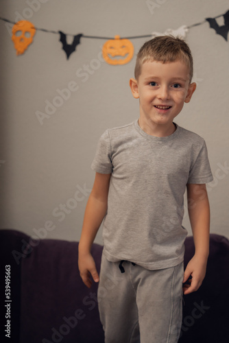 A boy stands on the background of Halloween decor, free space, halloween concept. High quality photo