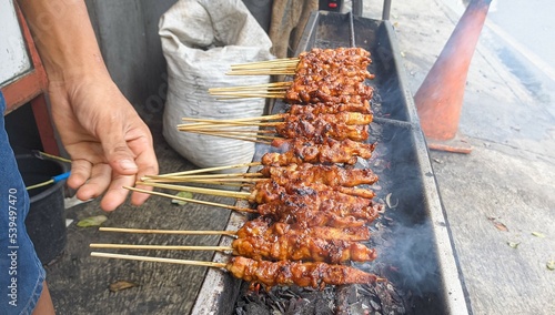 satay. is a typical indonesian food that is cooked by grilling. isolated when the process of turning satay takes place