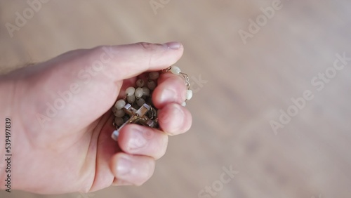 Hand of Christian Catholic Caucasian Male Praying with Holy Rosary