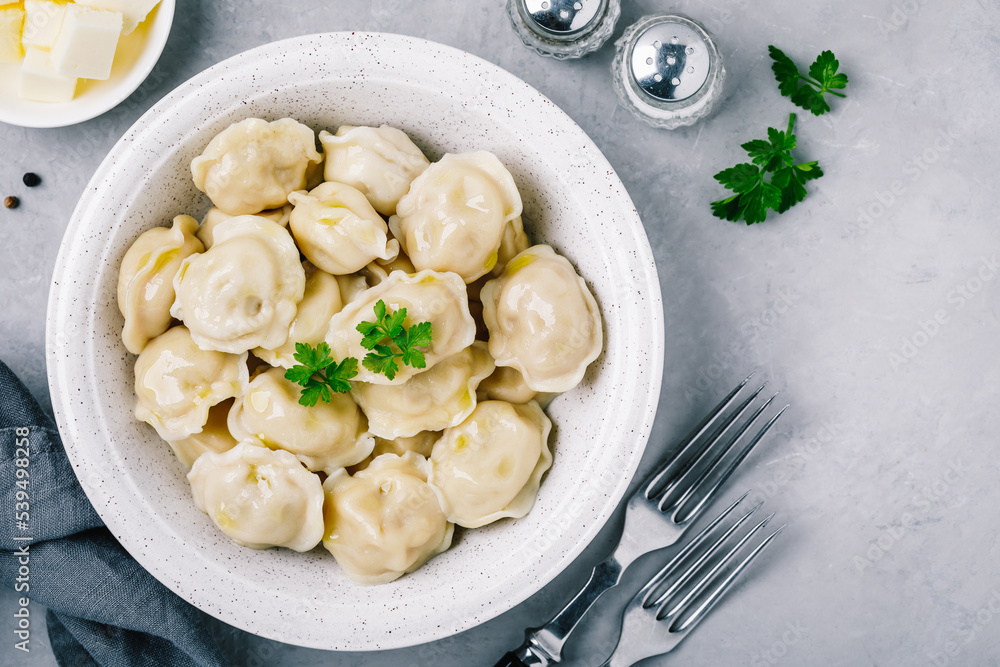 Dumplings. Meat stuffed Dumplings in a bowl on gray stone background.