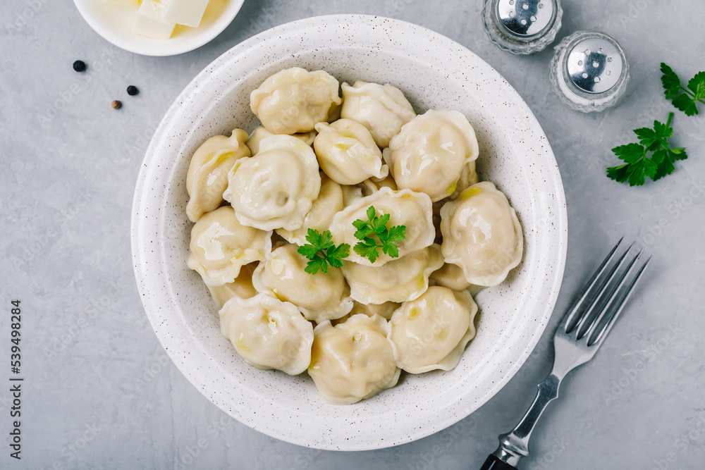 Dumplings. Meat stuffed Dumplings in a bowl on gray stone background. Dumplings. Meat stuffed Dumplings in a bowl on gray stone background.