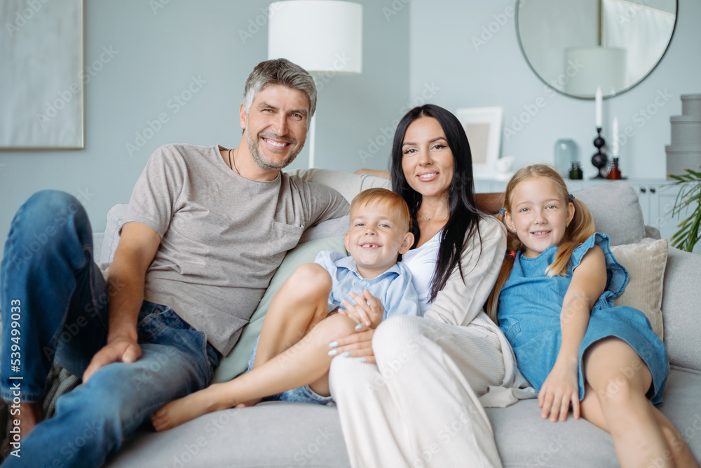 portrait of a happy family with children sitting on the sofa.