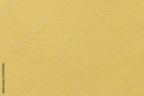 Texture of natural ocher color twill fabric close-up. the background for your mockup