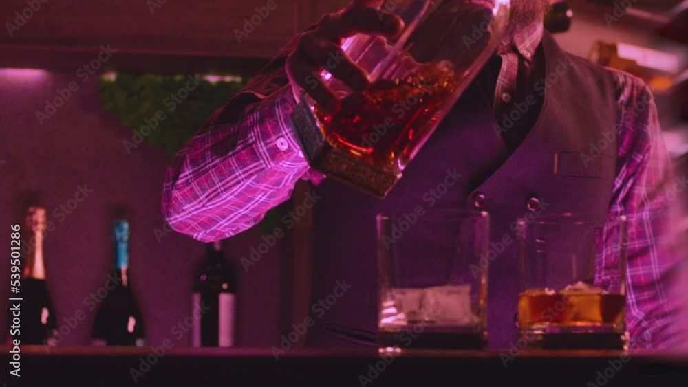 professional-bar-man-with-beard-pouring-brandy-scotch-or-whiskey-to