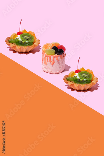 three cakes with cream, berries and fruits. Two delicious biscuits. cake basket with fresh tropical fruits. Beautiful background for cooking