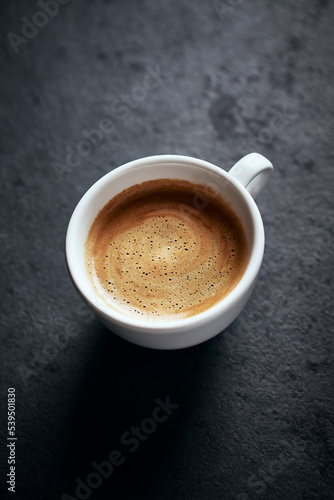 Cup of coffee on dark stone background. Close up. Copy space. 