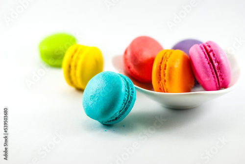 Colorful of macarons in a white ceramic bowl and placed on a white floor, selective focus.
