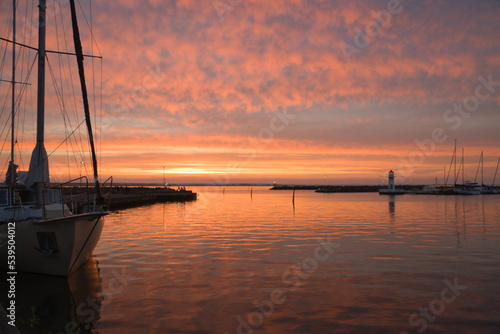 Sunset in Sweden at the harbor of lake Vaettern. Lighthouse in the background © Martin