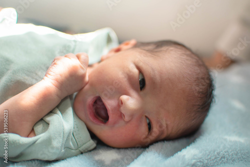 Bebé recien nacido del genero masculino bostezando 