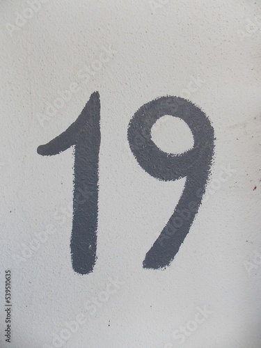number nineteen painted on a white wall