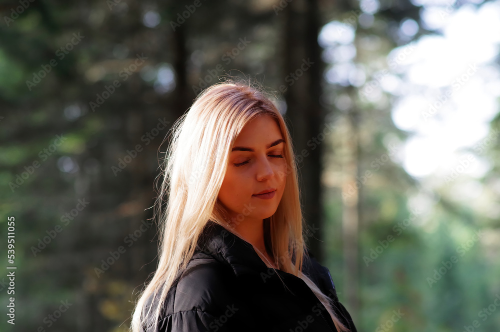 Blond kobieta w lesie jesienią z zamkniętymi oczami. Blond kobieta w lesie jesienią z zamkniętymi oczami.