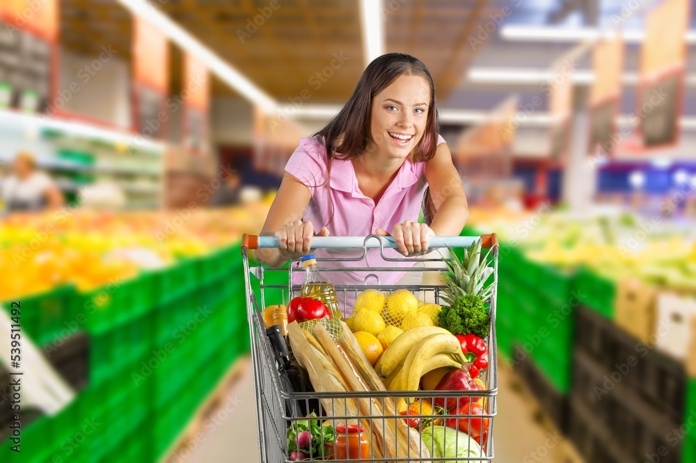 Happy woman buying food in big supermarket