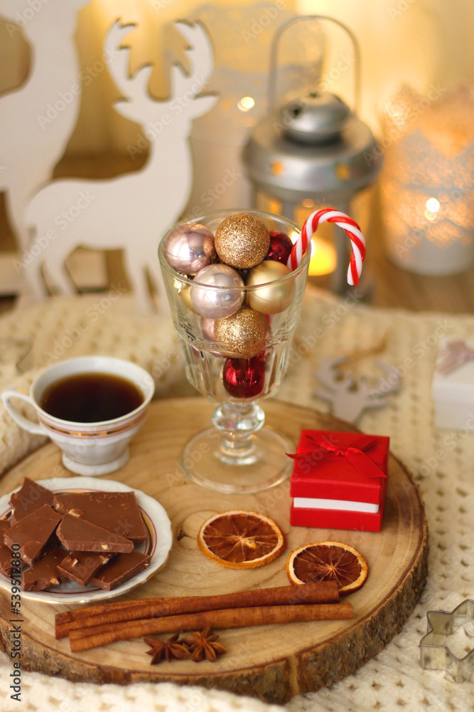 Various Christmas decorations, cup of tea or coffee, sweets, small presents, knitted blanket and candles. Selective focus.