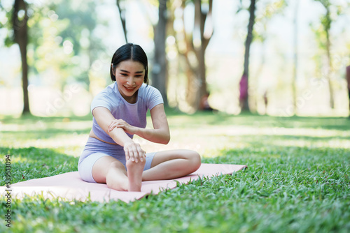 Beautiful young asian woman yoga exercising in the park.