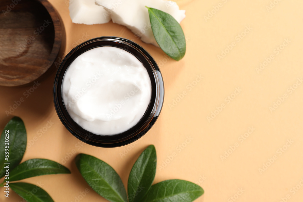 Flat lay composition with jar of coconut face cream on light orange background. Space for text Flat lay composition with jar of coconut face cream on light orange background. Space for text