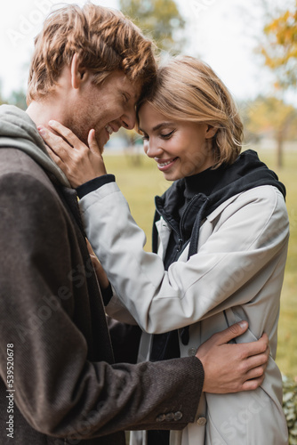 joyful young couple with closed eyes embracing in autumnal park during date. © LIGHTFIELD STUDIOS