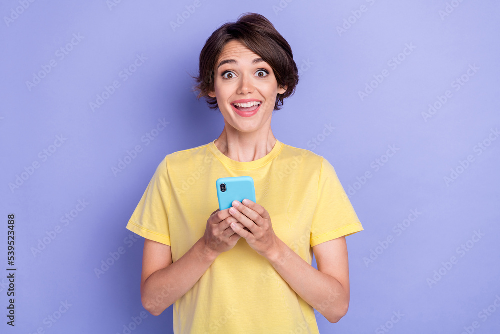 Portrait of astonished positive person toothy smile hold telephone isolated on purple color background Portrait of astonished positive person toothy smile hold telephone isolated on purple color background
