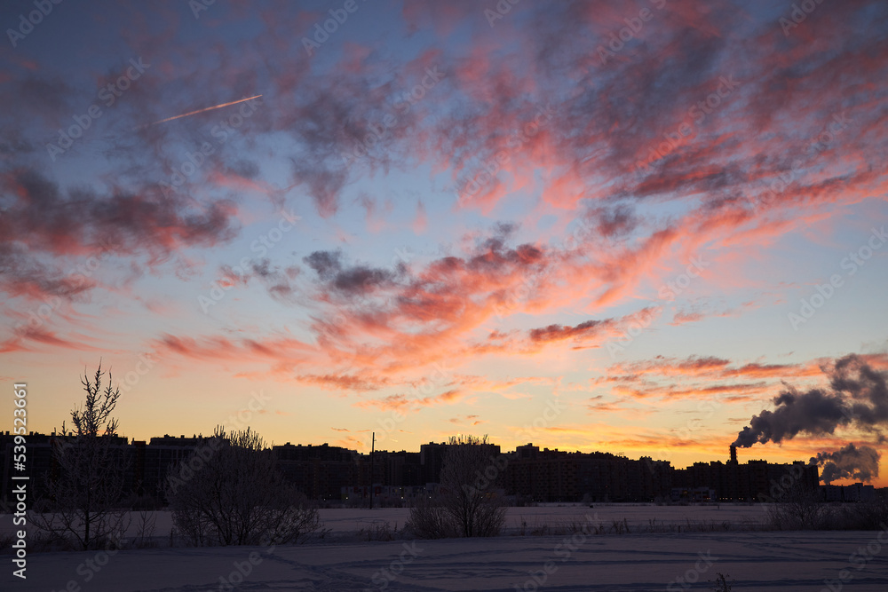 Fototapeta premium The silhouette of the night city, Darkening in the bright red sky..