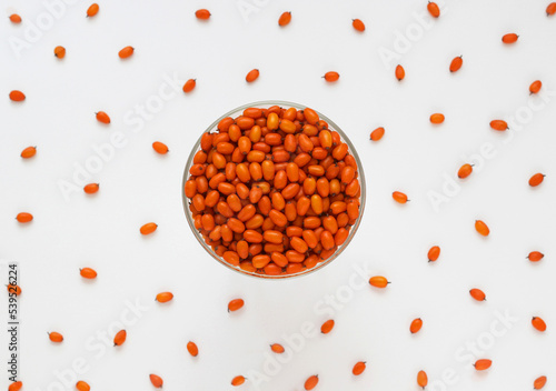 Sea buckthorn berries in bowl on white background. Top view. Selective focus. Orange berries of Hippophae plant. 