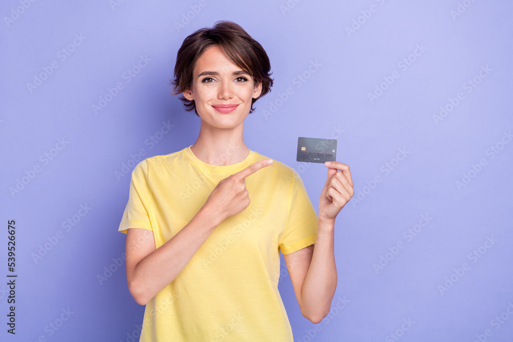 Photo of young attractive gorgeous nice woman wear yellow t-shirt finger pointing credit card user wireless payment new isolated on purple color background Photo of young attractive gorgeous nice woman wear yellow t-shirt finger pointing credit card user wireless payment new isolated on purple color background