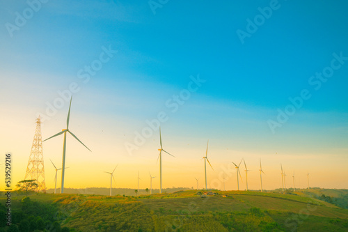 Wind turbines on beautiful sunny summer landsape. Green ecological power energy generation. Wind farm eco field
