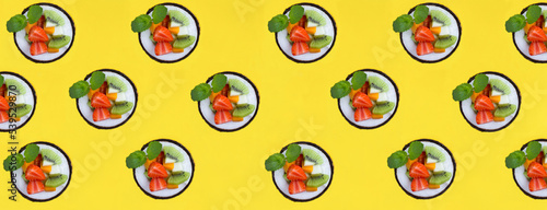 Fruit salad in the half coconut on the yellow background. Flat lay. Pattern.