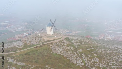 Typical old white Spanish windmills (Molinos appearing in Don Quijote) surrounded by a dry landscape in Consuegra, Toledo. Castilla la Mancha, Spain