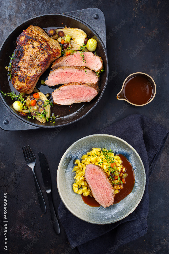 Tafelspitz Braten vom Kalb mit schwäbischen Spätzle serviert mit Dunkelbier Sauce als Draufsicht in einem Design Schale und Topf Tafelspitz Braten vom Kalb mit schwäbischen Spätzle serviert mit Dunkelbier Sauce als Draufsicht in einem Design Schale und Topf