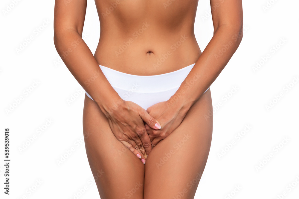 Cropped shot of a young woman in white panties holding her crotch with her hands, suffering from cystitis isolated on white background. Gynecological problems, genital tract infections. Healthcare