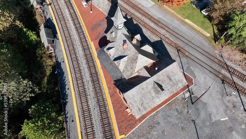 Rail train station depot in Point of Rocks Maryland beside forest hillside, Potomac River and small town American neighborhoods