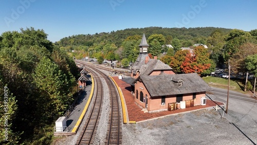 Rail train station depot in Point of Rocks Maryland beside forest hillside, Potomac River and small town American neighborhoods