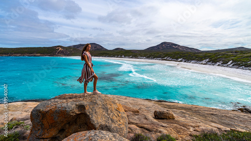 Quadro em tela girl in long dress stands on rocks admiring the power of the ocean; amazing beac