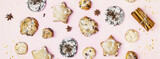 Winter holiday food banner with different kind of traditional home made christmas cookies on a pink background with holiday decoration. Hande made New Year sweet pastries. Christmas party