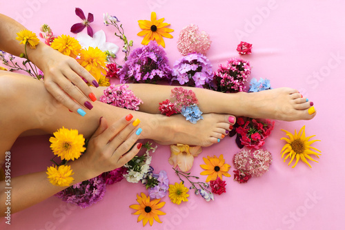 Multicolored manicure and pedicure on square shaped nails with different flowers. photo