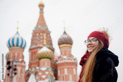 Concept tourist travel Christmas holidays Russia Moscow city. Winter portrait of young happy woman in wearing warm clothes