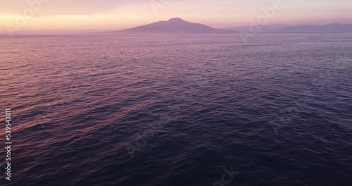 Beautiful sunset colors over the ocean, sea. Flying over sunset color sea, Vesuvio mountain in the background. Calm water. Orange, pink and blue. Tyrrhenian sea with volcano Mount Vesuvius photo