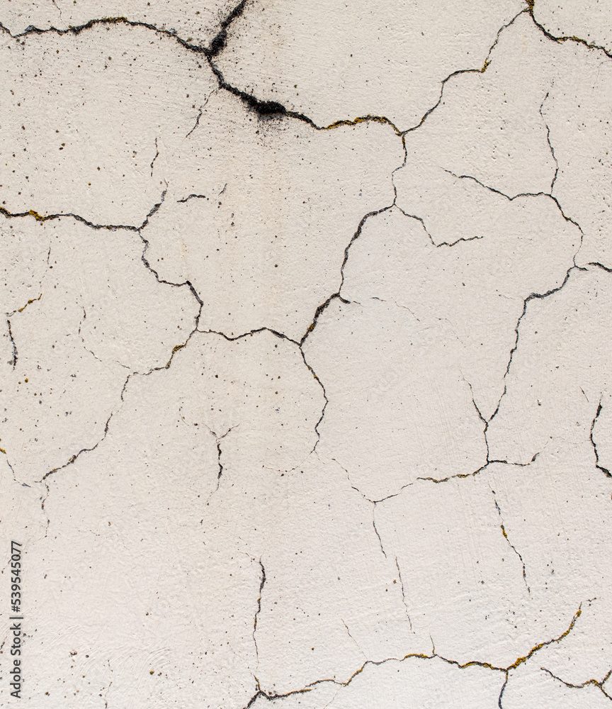 Cracked plaster on the wall of the house. Cracked plaster on the wall of the house.
