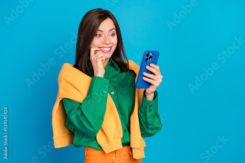 Photo of charming positive person finger touch lips use telephone facebook telegram whatsup instagram isolated on blue color background photo