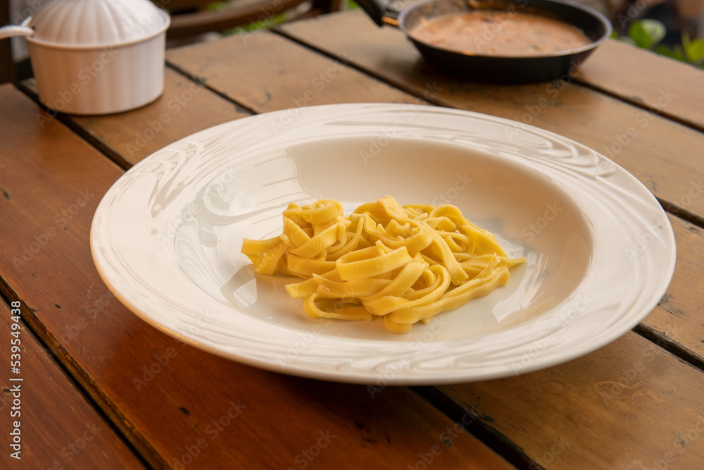 Italian pasta noodles without sauce on white plate